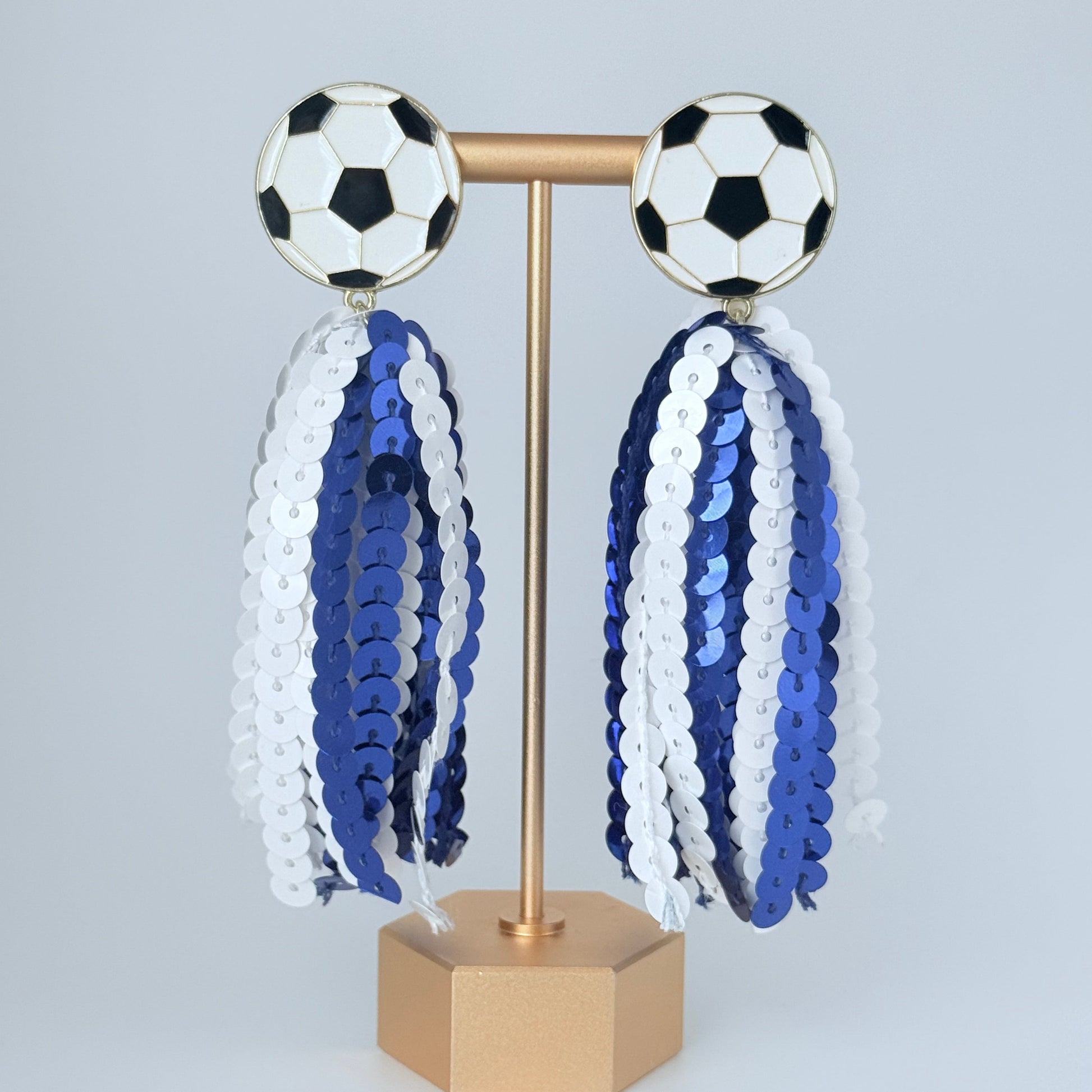 Decorative wall piece with soccer ball designs and sequined patterns on a light gray background