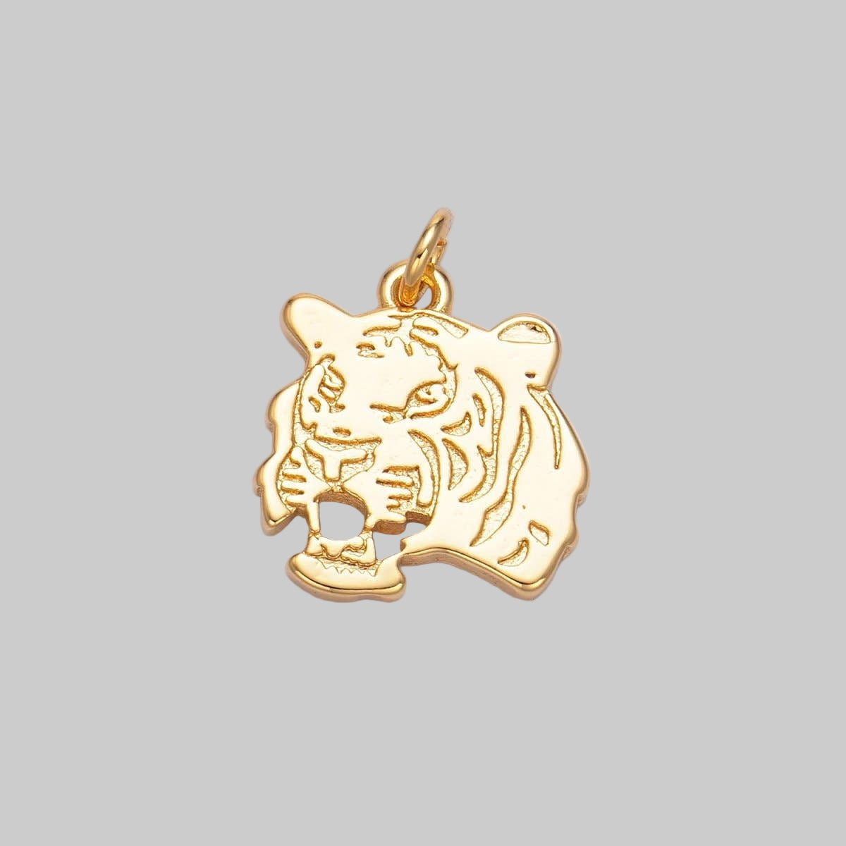 Gold tiger pendant on a light purple background