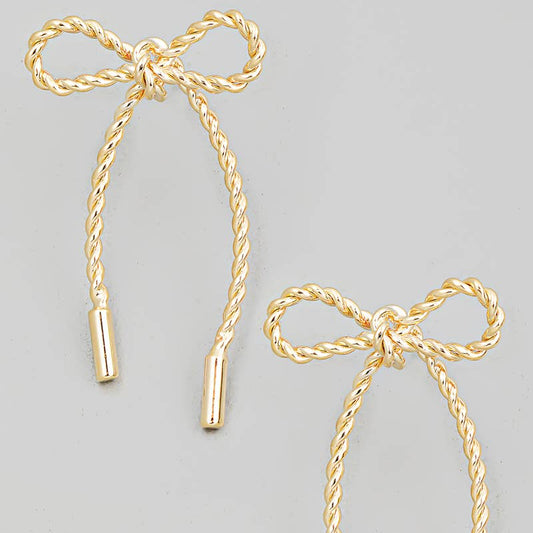 A pair of gold-colored twisted bow tie earrings with attached rope-like cords.