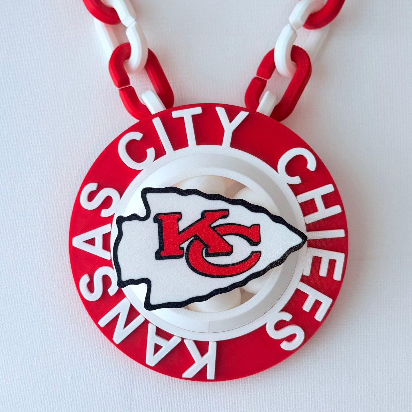 Kansas City Chiefs logo on a red and white chain against a white background