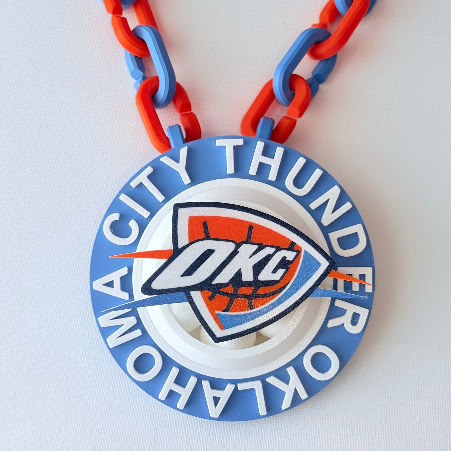 Oklahoma City Thunder logo on a blue and red chain against a white background