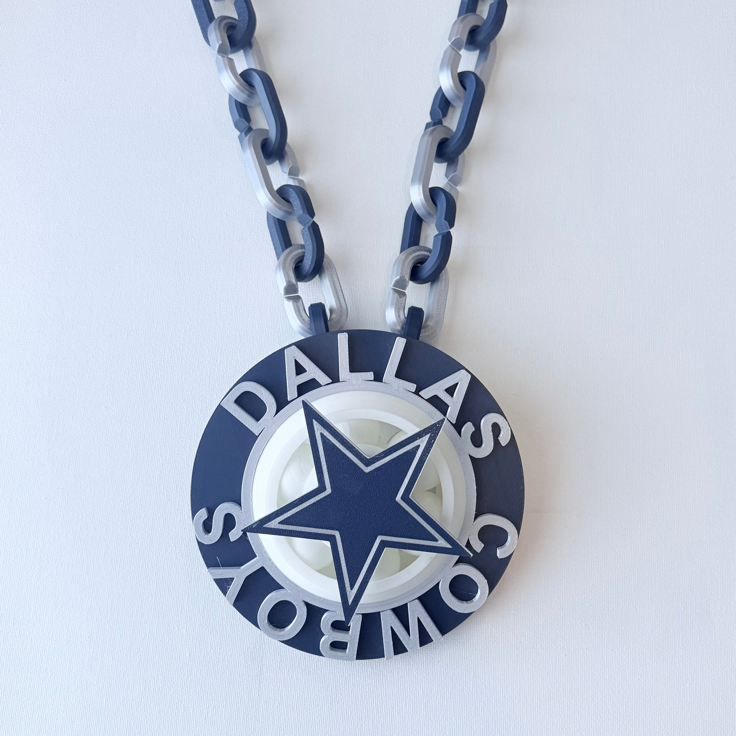 Dallas Cowboys necklace with blue and gray chain on a white background